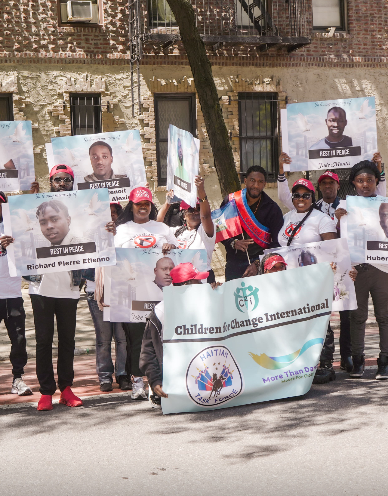Advocates in Brooklyn holding 'Rest in Peace' memorial signs beside a Children for Change International banner.